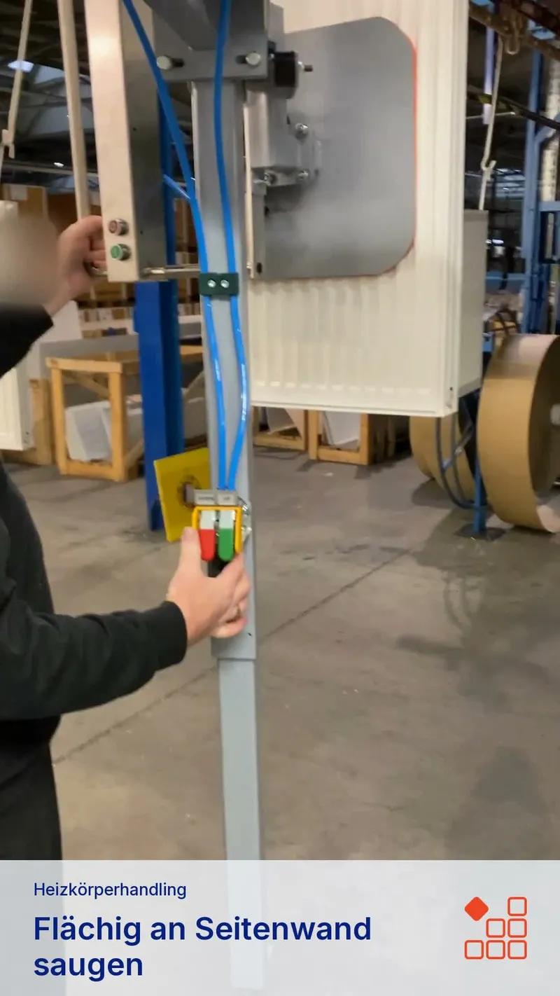 Side-mounted vacuum attachment holding a radiator on a guided lifting device.